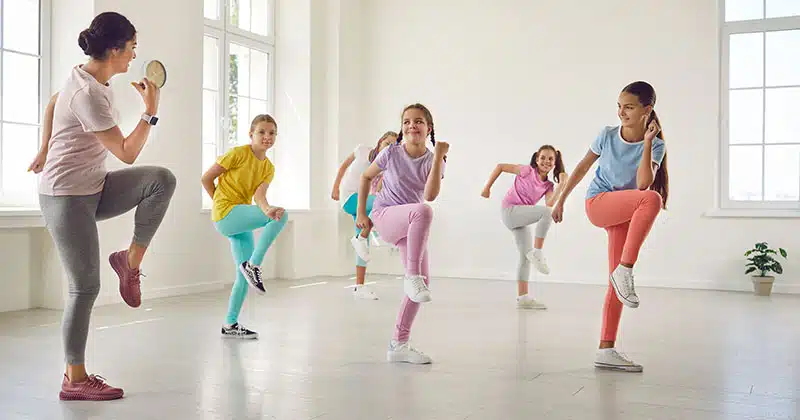 Kids with teacher practicing choreography in dance class