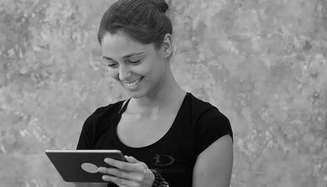 a person smiling while looking at a tablet