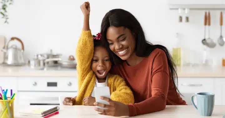 a mother and a daughter looking at a mobile device together