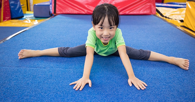 Preschool-aged girl stretching and smiling