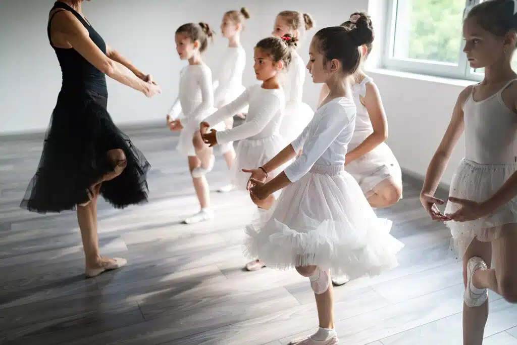 Group of children exercising ballet in studio together