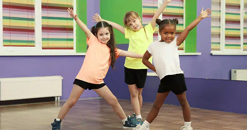 Three kids strike a pose in dance class