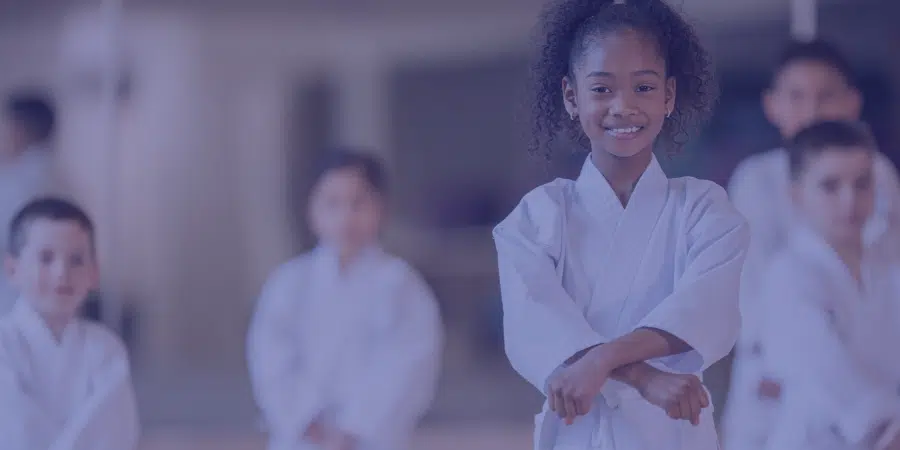 a young person smiling at a martial arts class