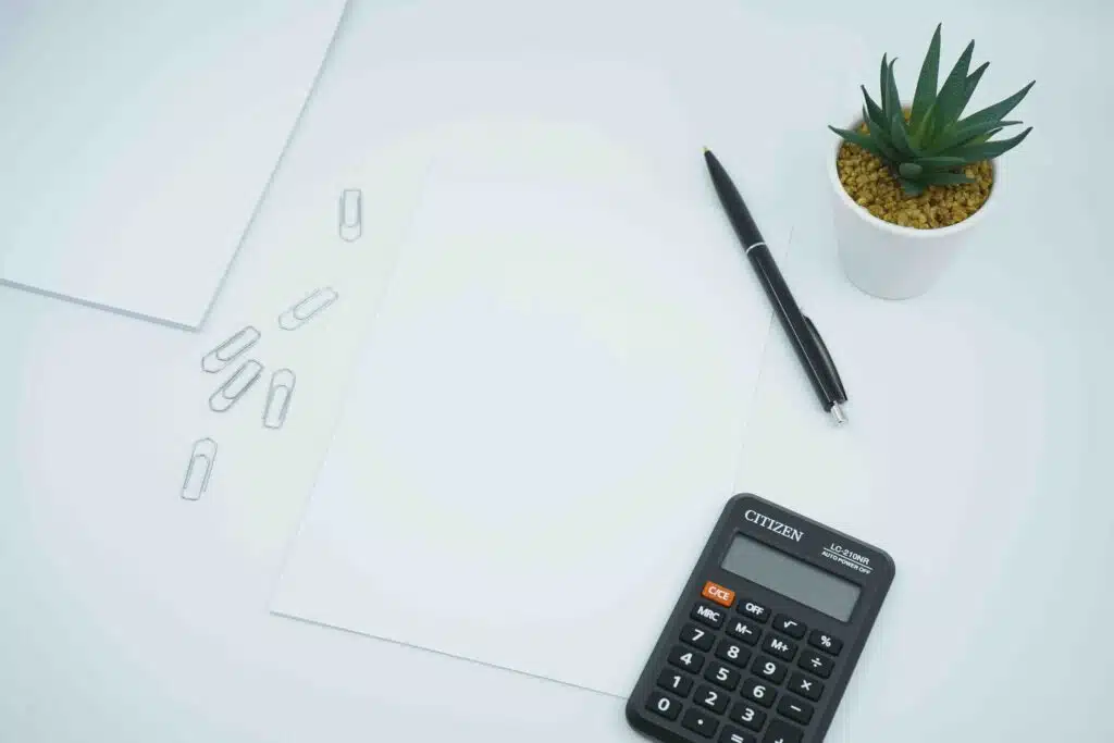 a calculator next to a pen on a table