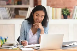 a woman working at a desk and looking at their computer