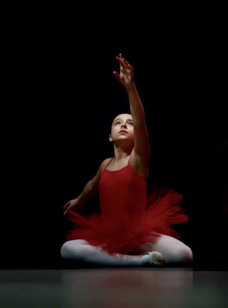 a young person reaching to the sky at a recital
