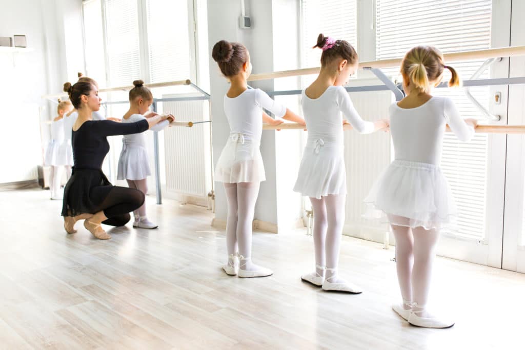 little ballerinas being instructed by a teacher