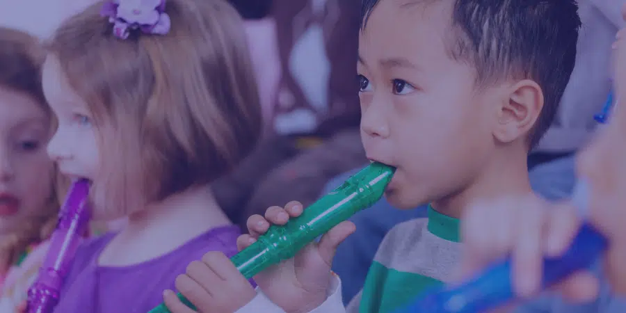 a young child playing recorder