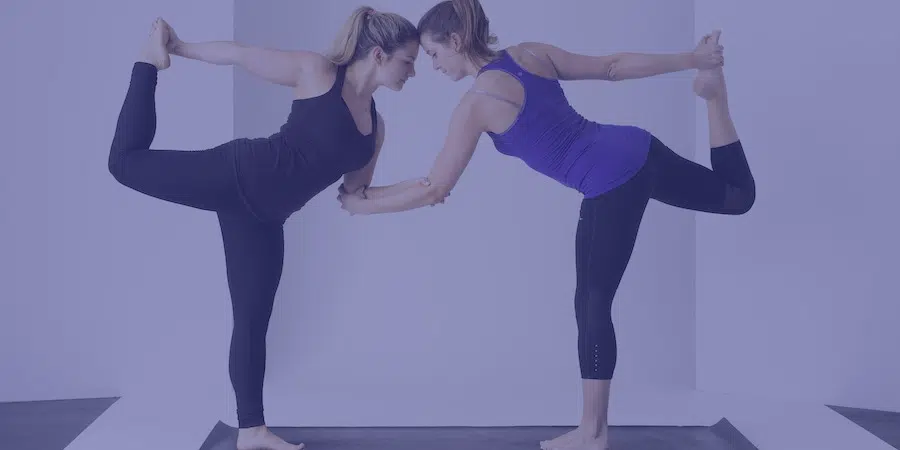 two people posing in a yoga class